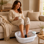 Woman relaxing on the couch with a mug in hand, feet soaking in the ionic foot spa