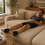 Man lying on a sofa with a heated foot massager on each foot