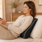 Woman sitting on a sofa using the cushion behind her lower back while on her phone