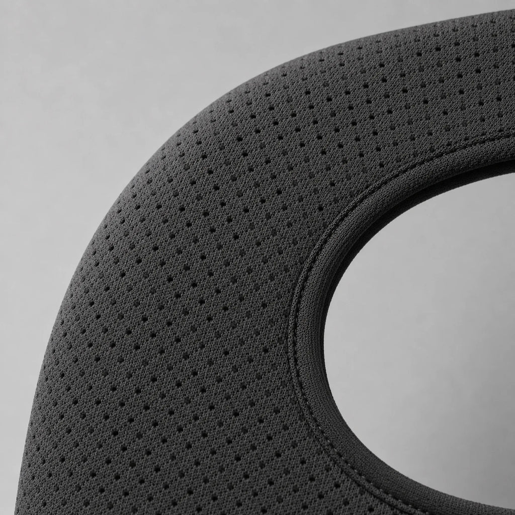 Close-up of the shoulder brace's perforated breathable strap fabric, showing the mesh weave and stitched seam